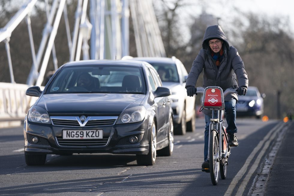 A car and cyclist on a busy road