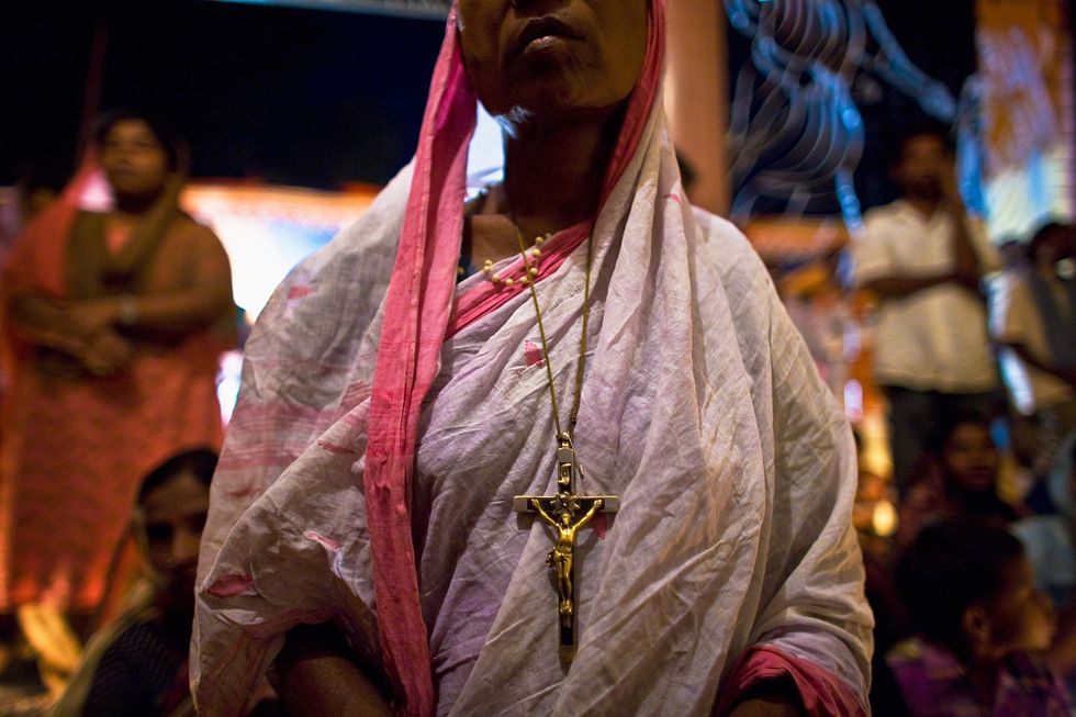 A Christian woman prays during a midnight prayer service at the Our Lady Of Charity Church on April 11, 2009