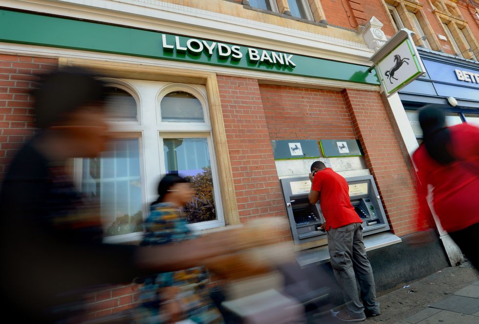 A customer uses an ATM machine outside Lloyds Bank in Camberwell, London