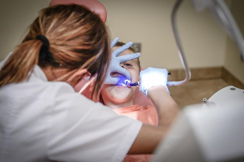 A dentist inspecting a child's teeth