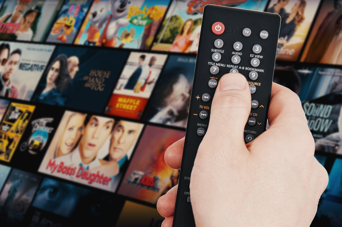 a hand holds a remote control with a tile of films tv shows and documentaries available to watch free of charge on fawesome streaming service 