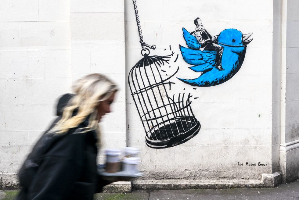 a man on a blue bird spray painted on the side of a building