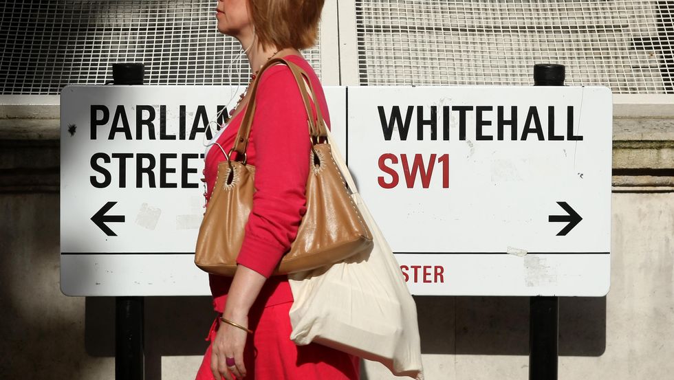 A pedestrian walks past a sign on Whitehall, in Westminster, central London.