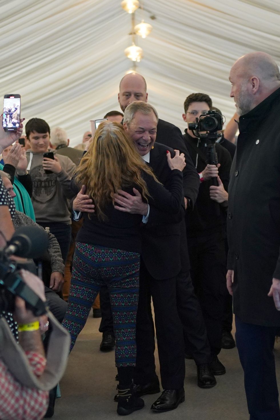 A person hugs Reform UK leader Nigel Farage during the Reform UK East of England conference at Chelmsford City Racecourse.