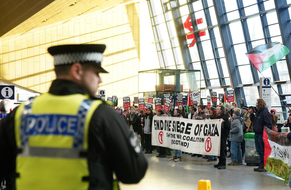 A police officer as pro-Palestine protesters gather at Glasgow train station