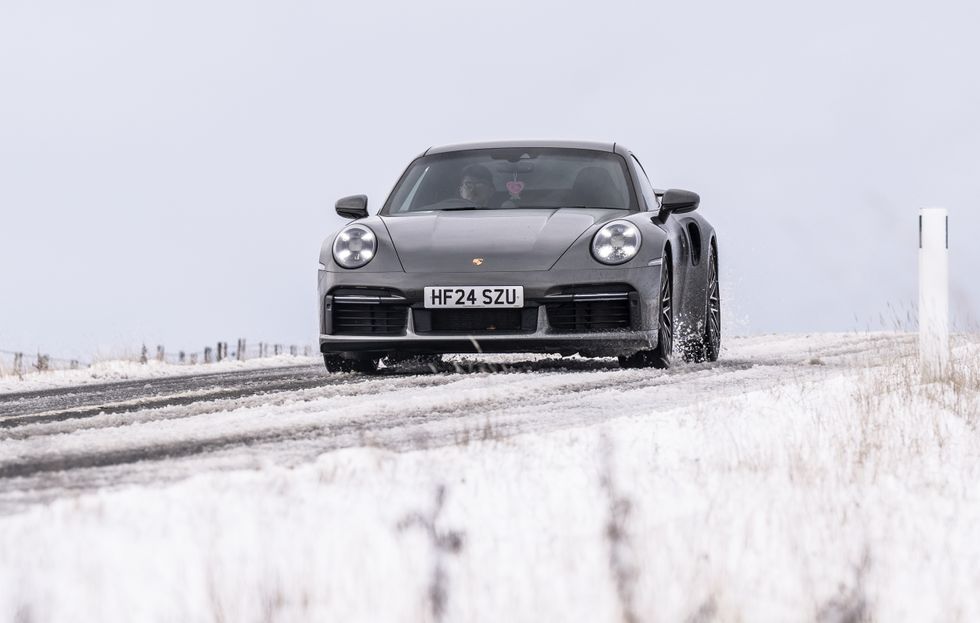 A Porsche drives in the snow along the A57 Snake Pass