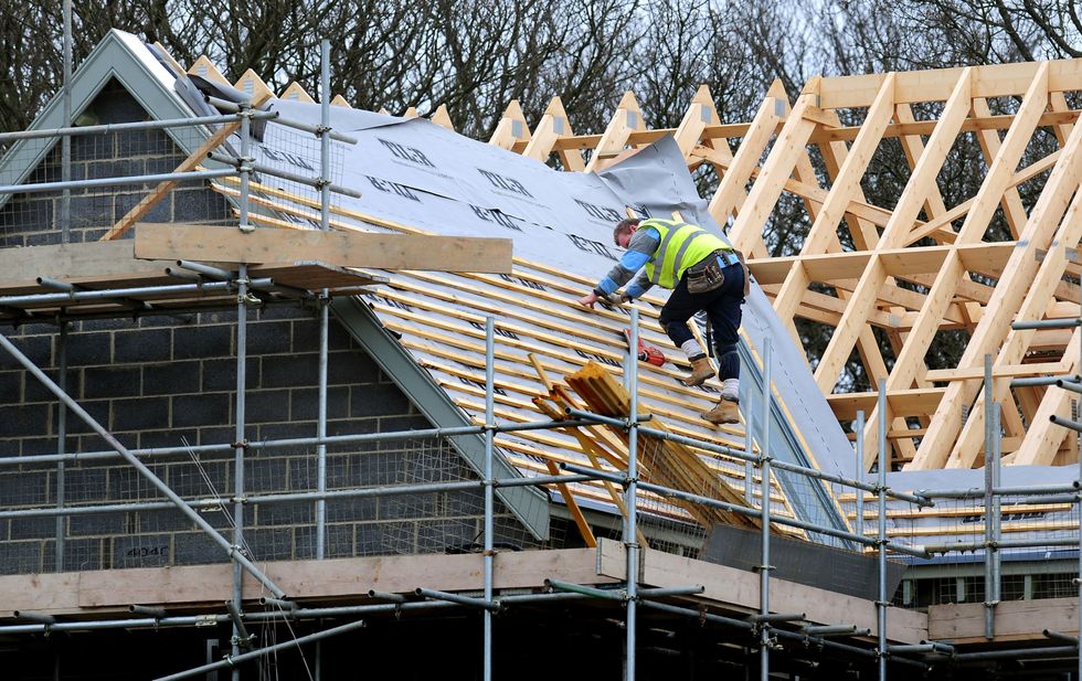 A stock image of a construction worker on a roof