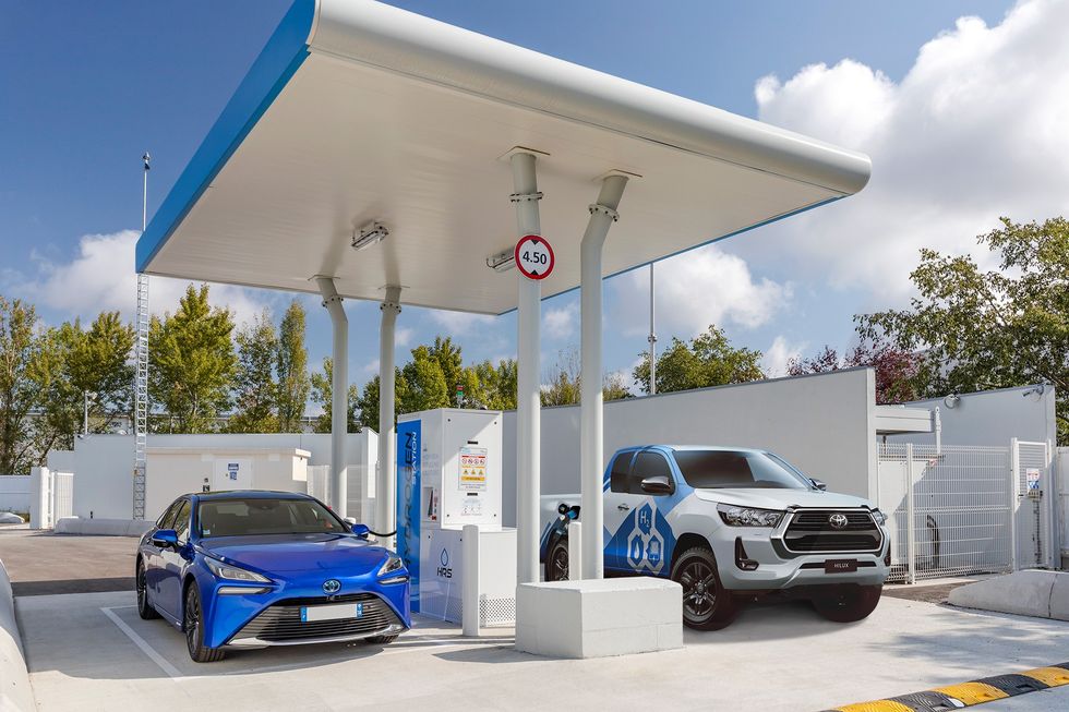 A Toyota car and pick-up truck refuelling at a hydrogen filling station