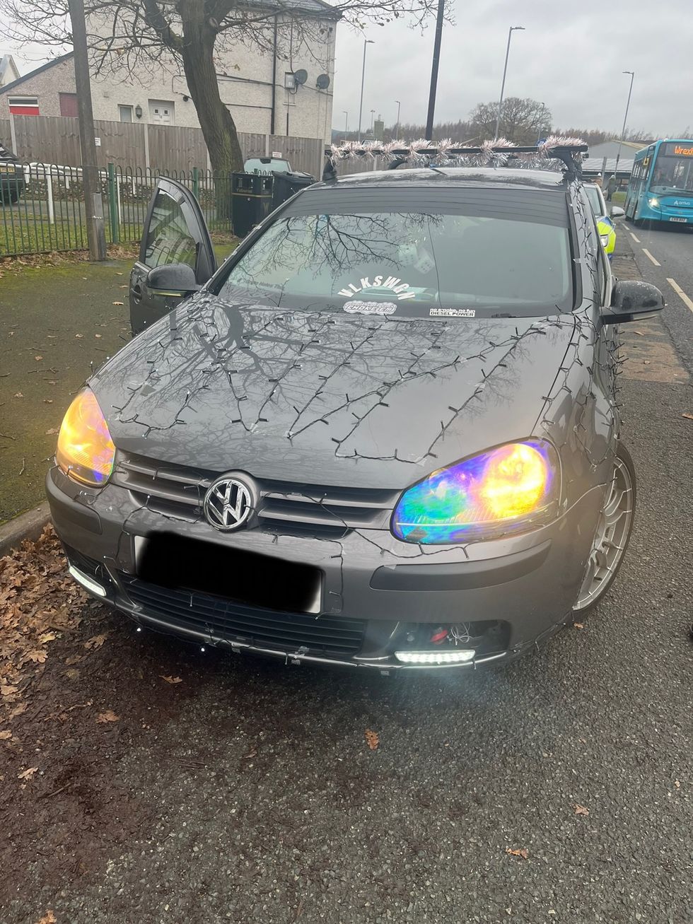 A Volkswagen with Christmas lights taped on the bonnet 