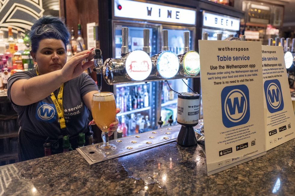 A Wetherspoon worker pulls a pint