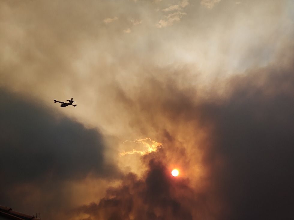 An aircraft in the sky as the wildfire rages on