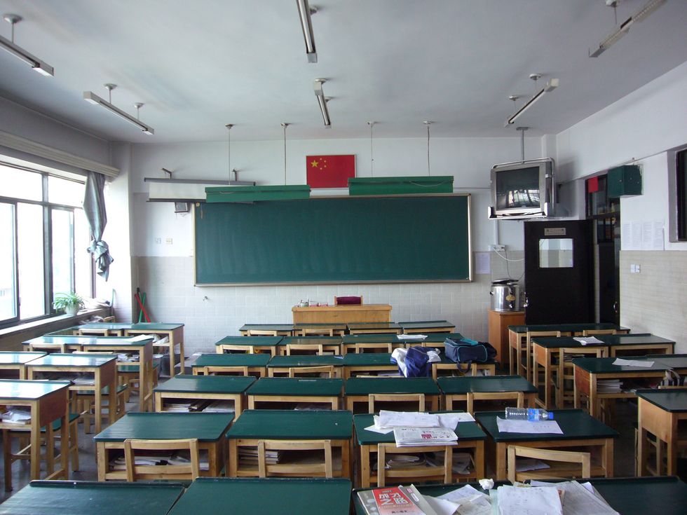 An empty classroom with a few textbooks on the tables