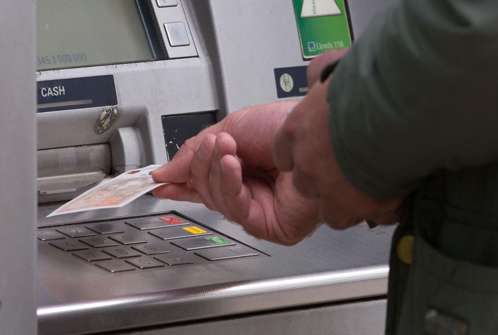 An image of a man taking cash out of an ATM