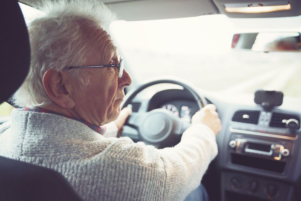 An older person driving a car