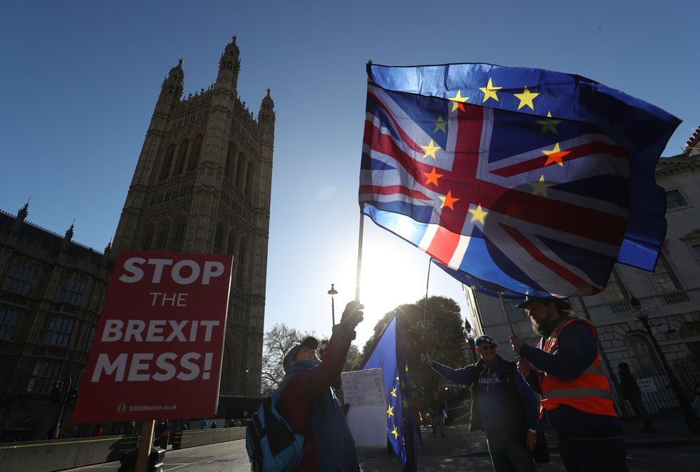 Anti-Brexit campaigners wave Union and European Union flags outside the Houses of Parliament