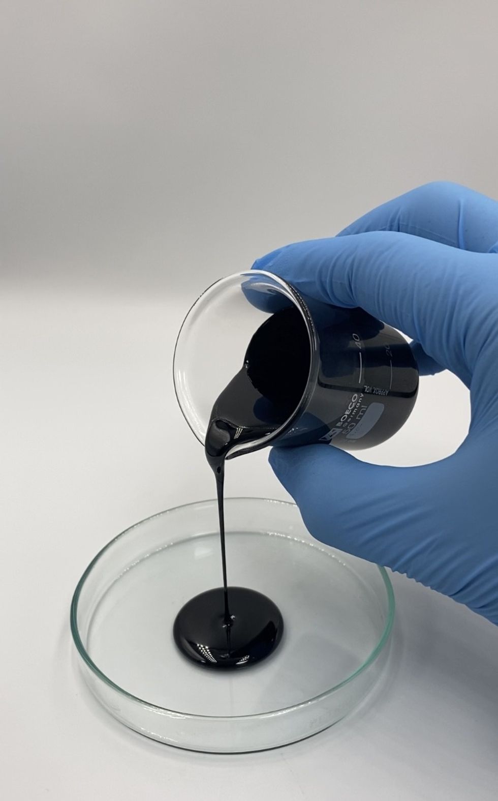 Bitumen flowing over a petri dish symbolises its unique property of transitioning into a liquid state at temperatures above its pour point