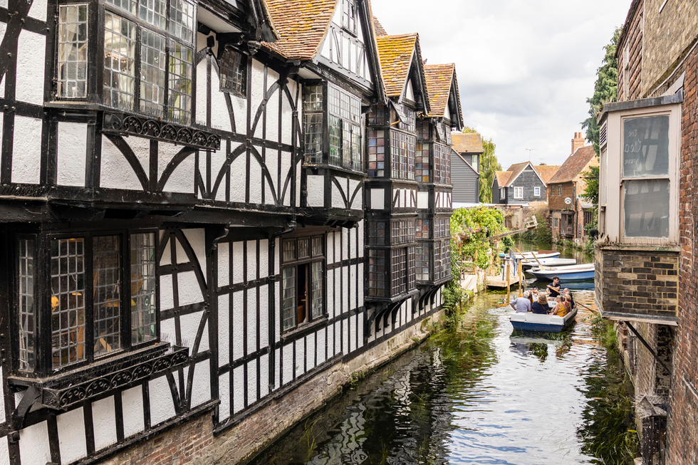 boat pictured going down a canal with houses on either side in Canterbury