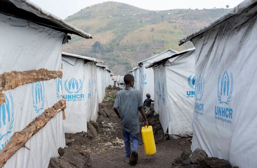 Boy walking down a UNHCR zone with water