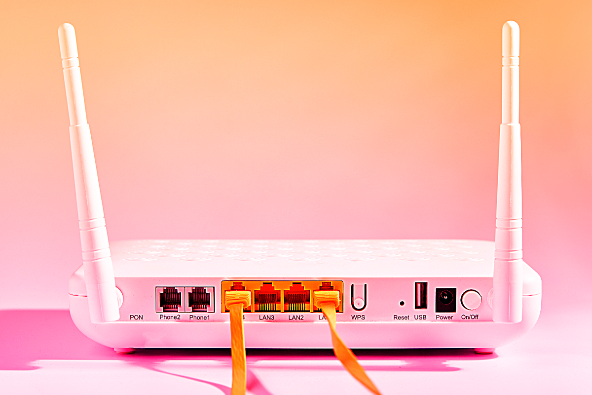 broadband router pictured with two ethernet cables plugged in 