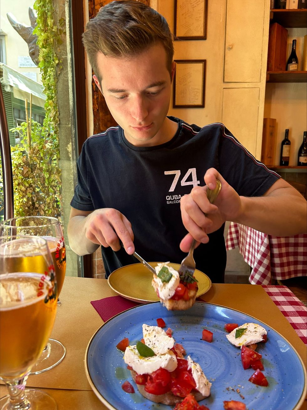 Cameron Walker tucks into bruschetta at table in restaurant