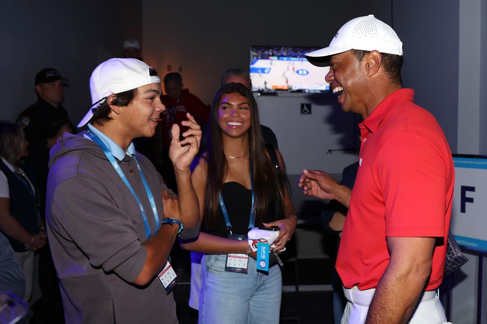 Charlie Woods and Tiger Woods share a laugh at the SoFi Center