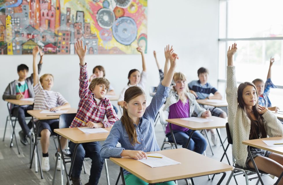 Children raising their hands in the classroom