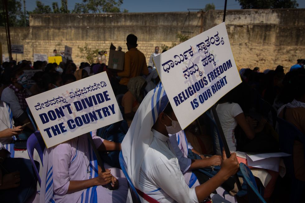 Christian nuns wave placards as they listen to a speaker during a demonstration against the tabling of the Protection of Right to Freedom of Religion Bill on December 22, 2021