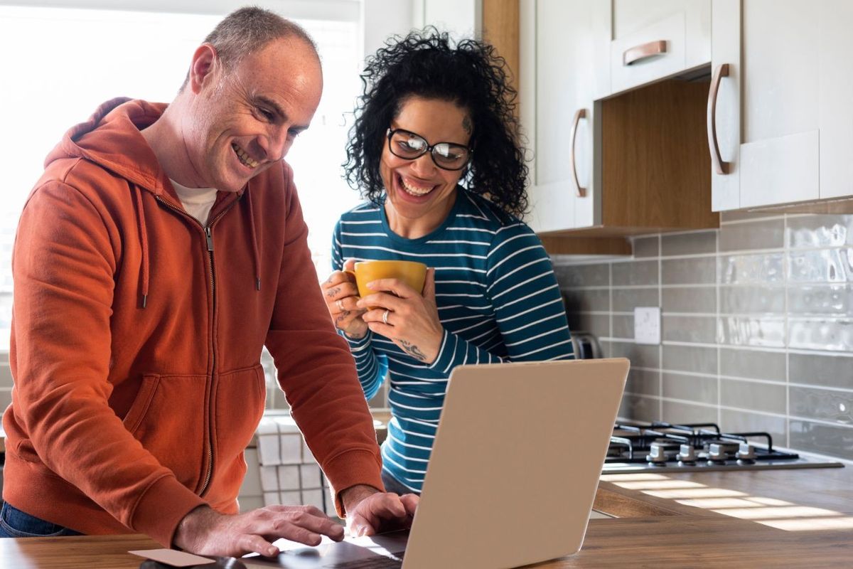 Couple look happy at laptop