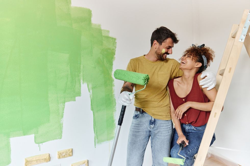 Couple painting walls green