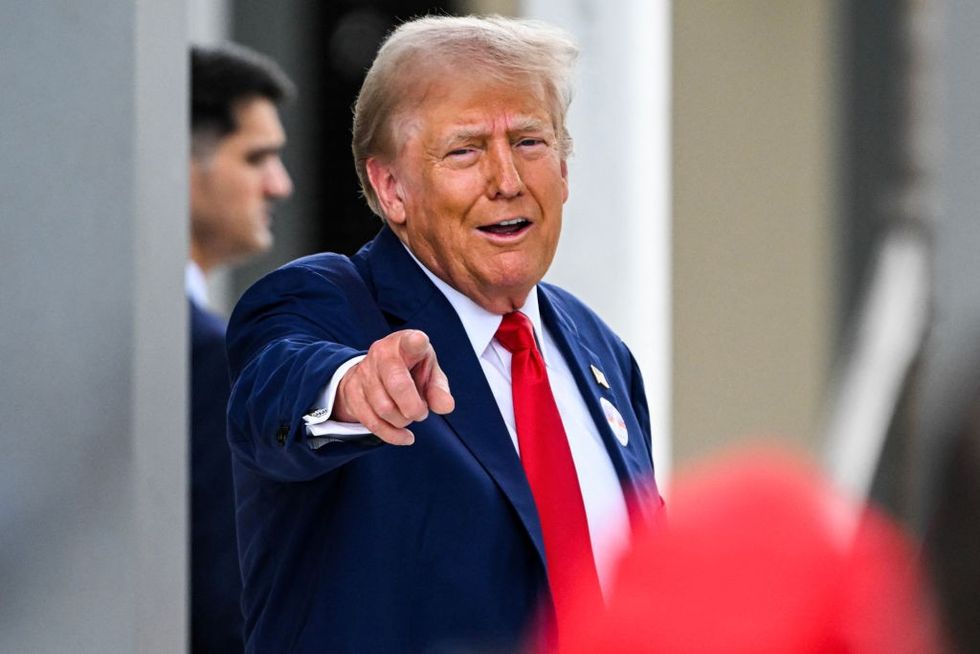 Donald Trump gestures toward a supporter