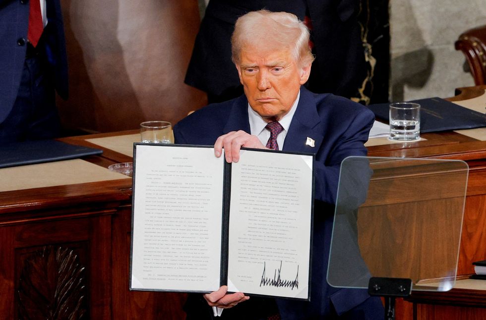 Donald Trump holds a copy of an executive order honoring Jocelyn Nungaray