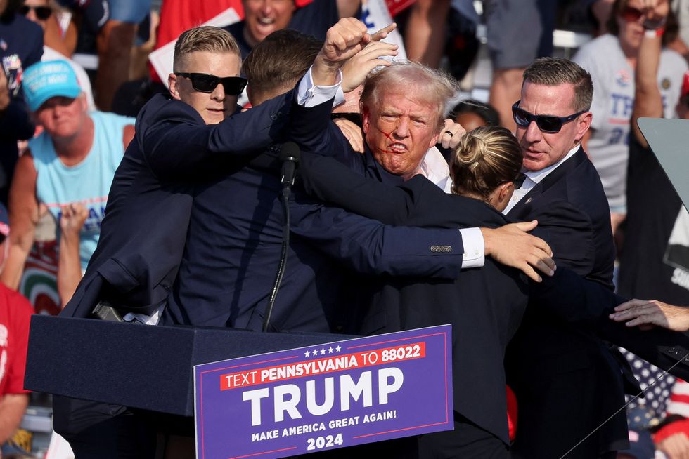 Donald Trump pumps fist in the air after assassination attempt