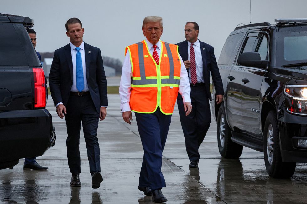 Donald Trump wears a high-vis vest, as he walks on tarmac at Green Bay Austin Straubel International Airportu200b