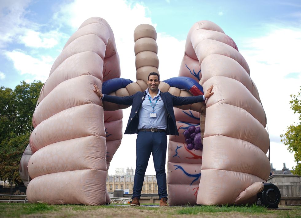 Dr Chris George, NHS medical doctor, beside a large inflatable lung at St Thomas' Hospital in central London, during the launch of the Let's Talk Lung Cancer Roadshow