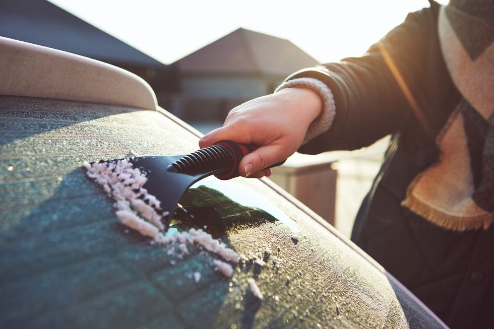 Driver clearing windscreen frost