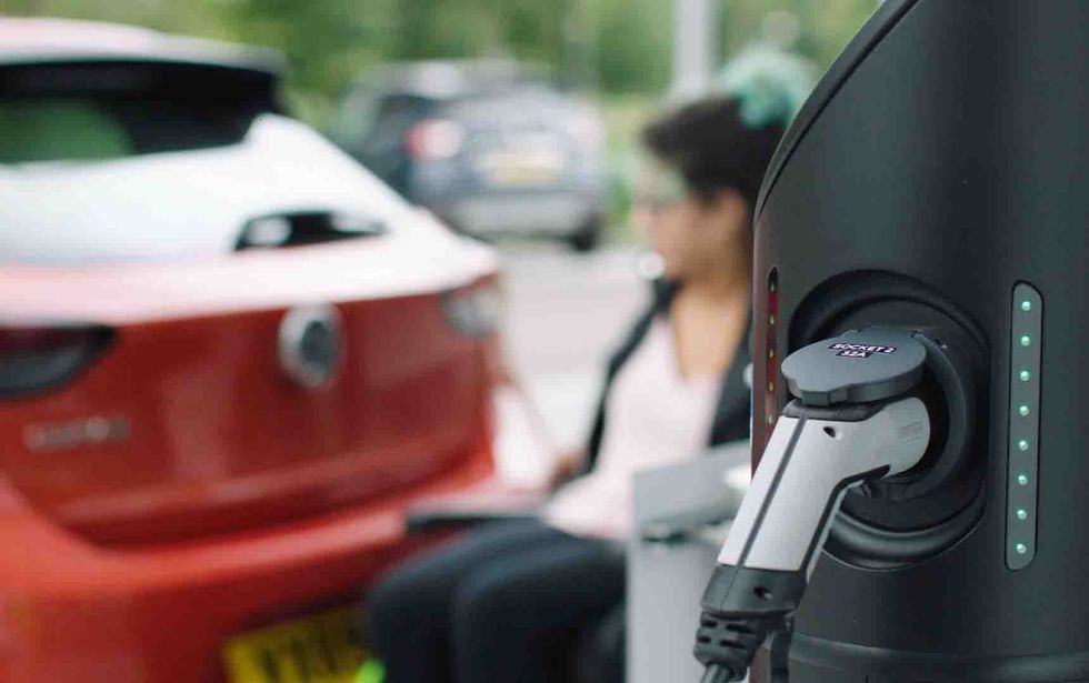 Electric car charger being used by person with disabilites