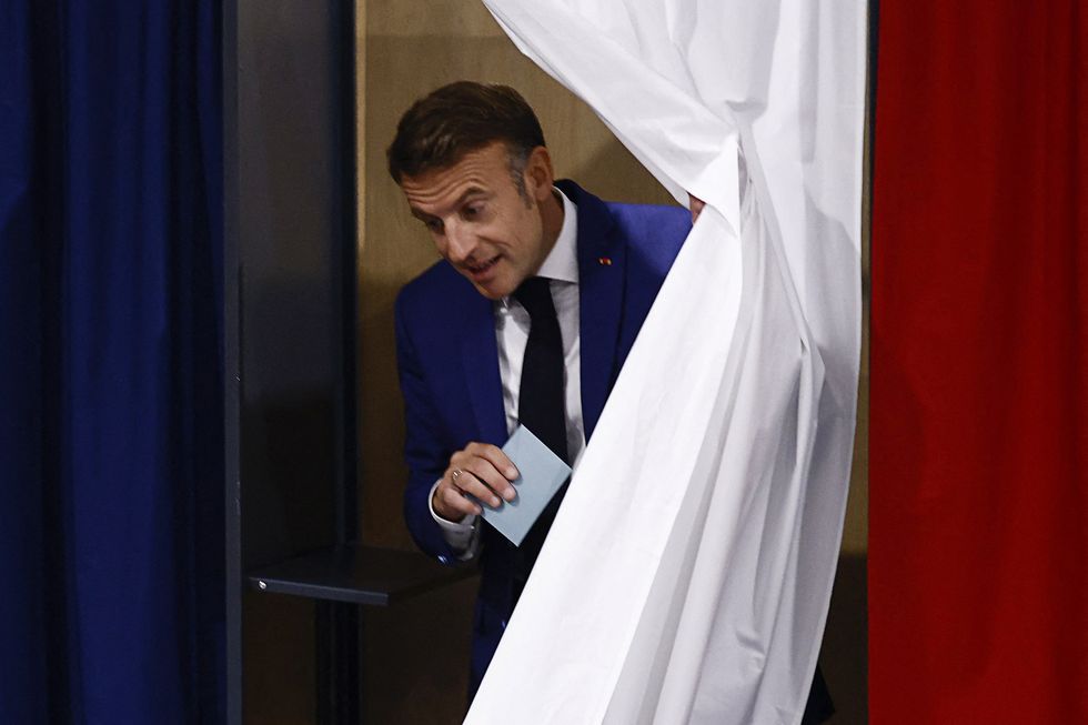 Emmanuel Macron leaves a voting booth, as he visits a polling station to vote in the first round of the early French parliamentary elections, in Le Touquet-Paris-Plage, France