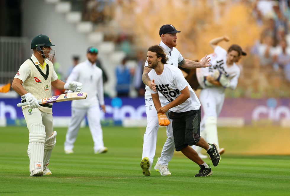 England captain Ben Stokes seen with a Just Stop Oil protestor