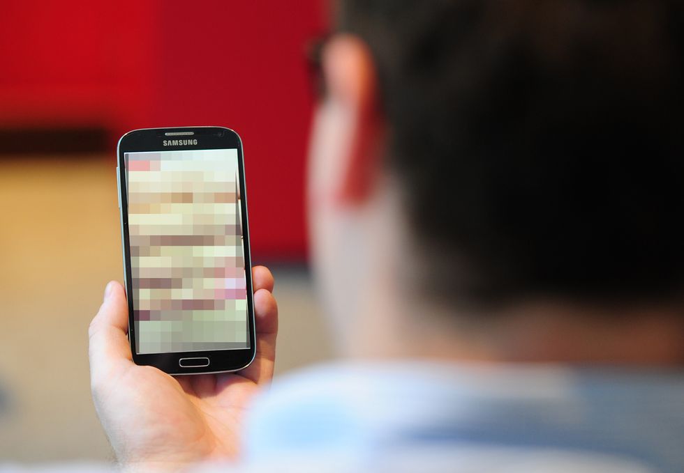 File photo of man holding phone with blurred screen