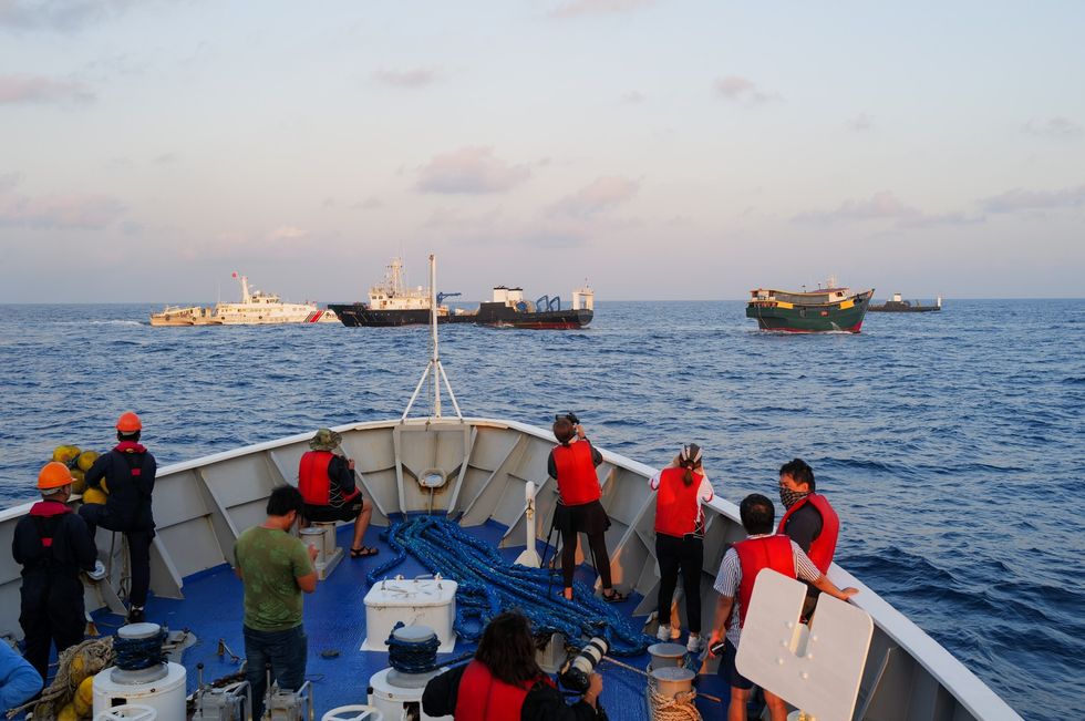 Filipino coast guard crews and journalists on board a ship