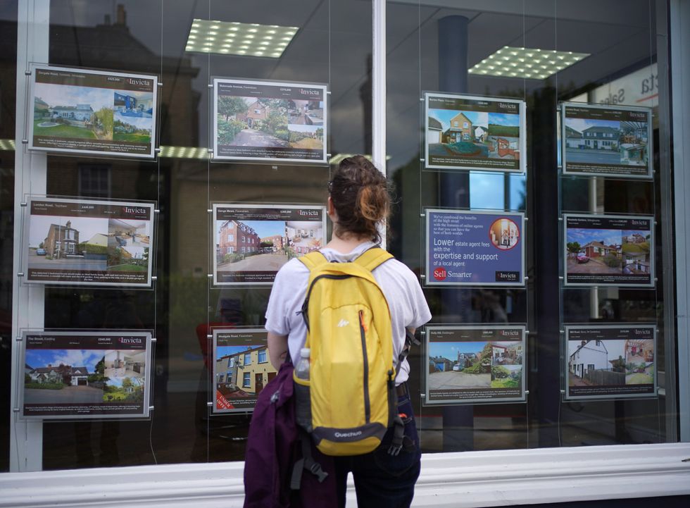 First time buyer looks at property in estate agent window