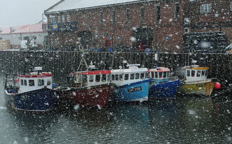 Fishing boats take shelter from the heavy snow in Scarborough harbour