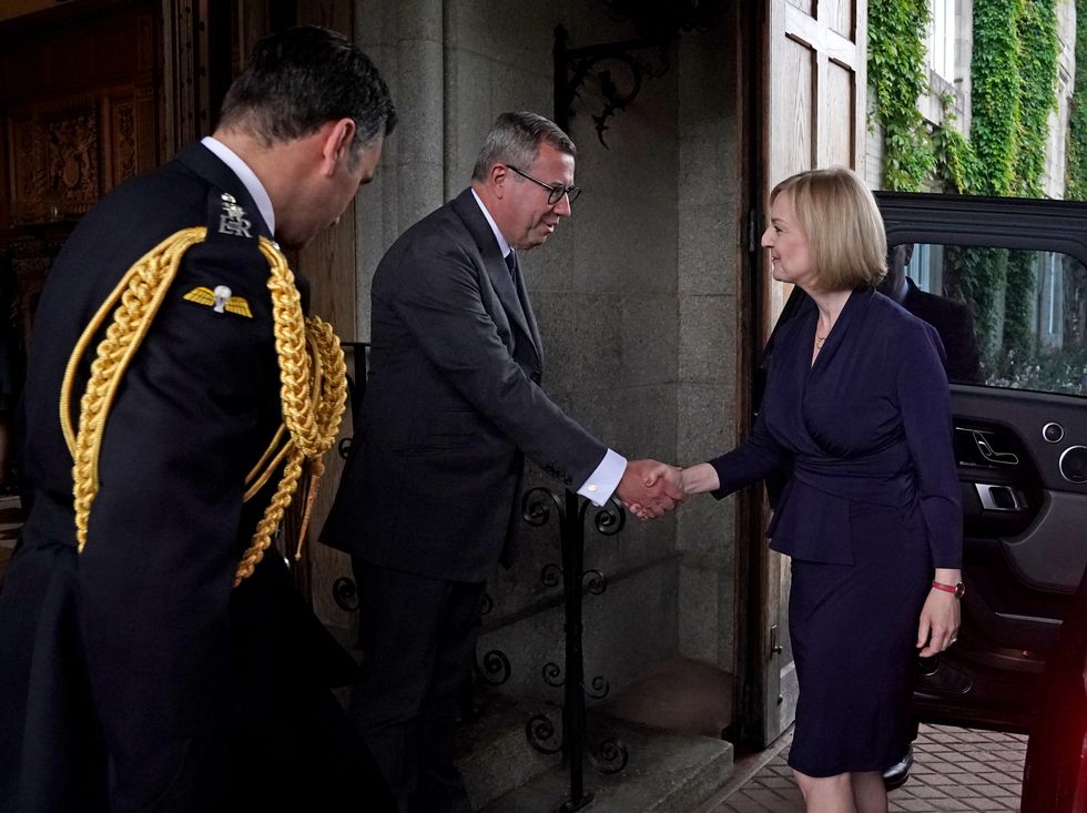 Former PM Liz Truss is greeted by Queen Elizabeth II's Equerry Lieutenant Colonel Tom White and her Private Secretary Sir Edward Young