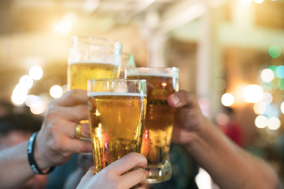 Group of happy friends drinking and toasting beer at brewery bar restaurant