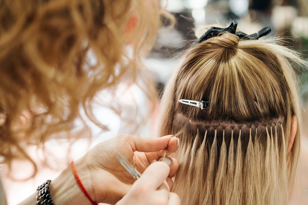 Hairdresser fitting hair extensions