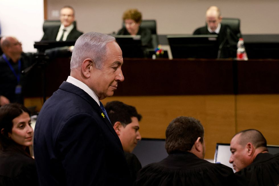 Israeli Prime Minister Benjamin Netanyahu enters the district court in Tel Aviv at the start of his hearing on corruption charges