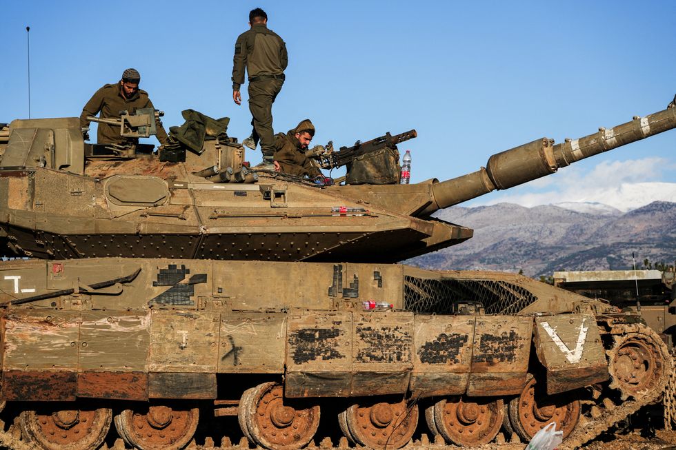 Israeli soldiers work on a tank amid cross-border hostilities between Hezbollah and Israel