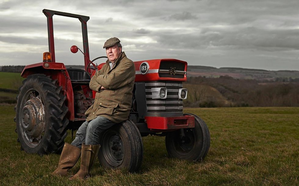 jeremy clarkson leans on a tractor in a promotional shot for his Clarksons Farm series on Prime Video