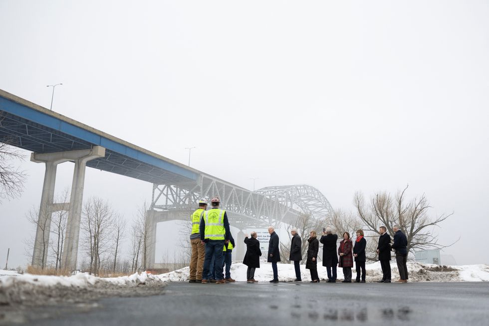 Joe Biden listens to remarks by Wisconsin Secretary of the Department of Transportation Craig Thompson while surveying the John A. Blatnik Bridge in Superior