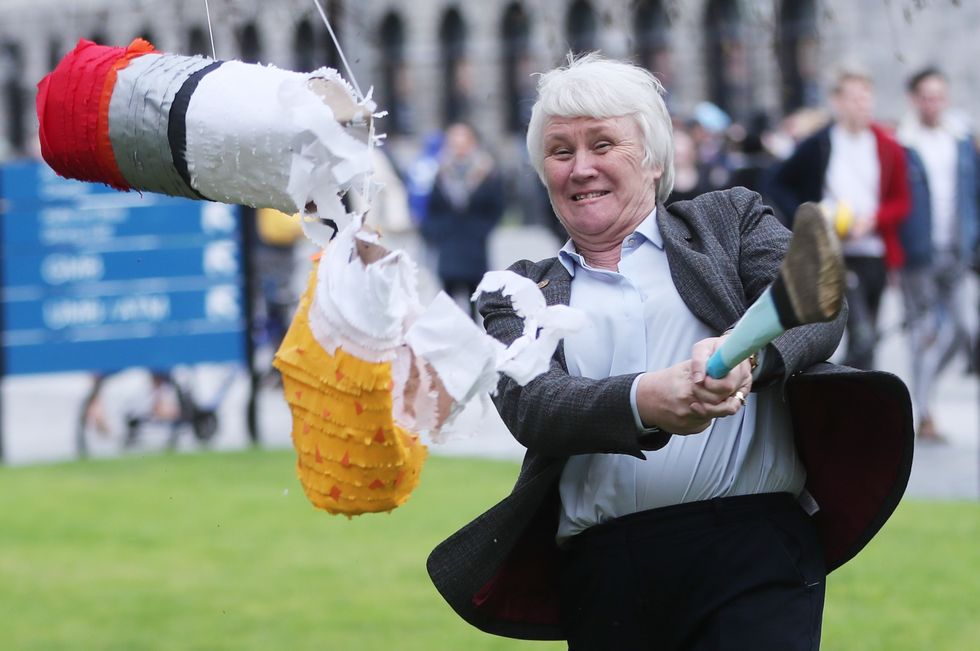 Junior Minister for Health Catherine Byrne smashes a pinata full of cigarette butts as she launches the campaign for a tobacco free campus for Trinity College as part of National No Smoking Day.